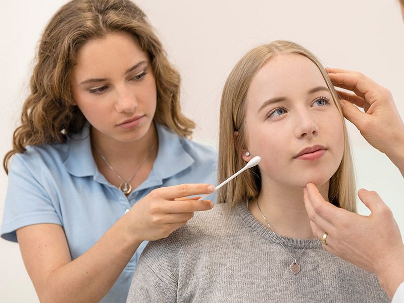 Behandlung von Pubertätsakne (Akne vulgaris) bei einer Jugendlichen mit Pickeln im Gesicht von einer Hautärztin 